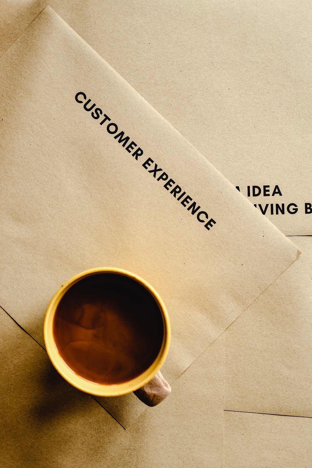 Eine Tasse Kaffee auf einem Briefumschlag, auf dem Customer Experience steht.